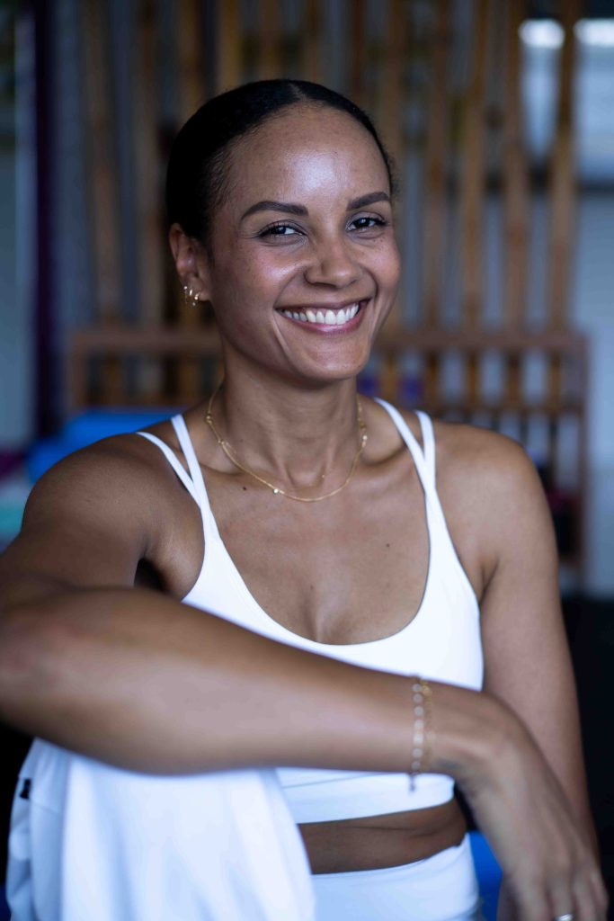 Femme souriante en tenue de sport blanche après une séance